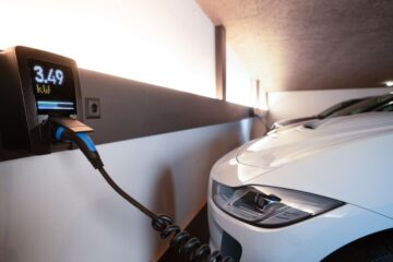Een persoon koppelt een thuisbatterij aan een energiesysteem met zonnepanelen voor duurzame energieopslag.